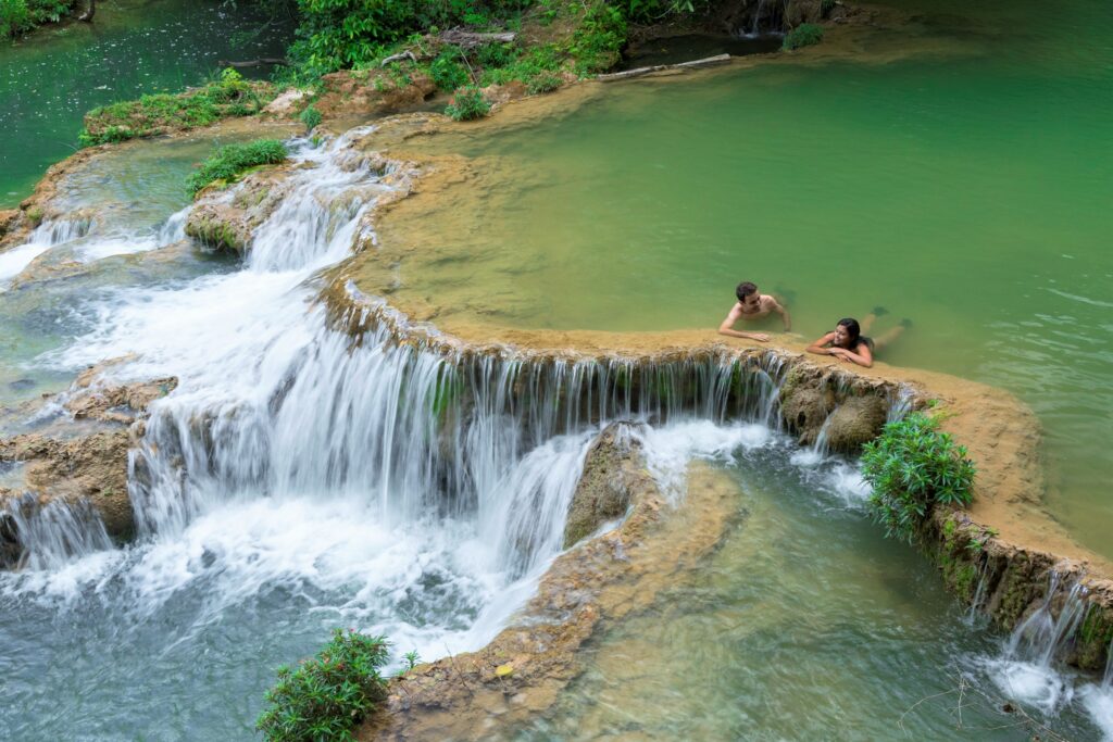 Casal relaxando em piscina natural com águas cristalinas nas cachoeiras na Estância Mimosa em Bonito MS.